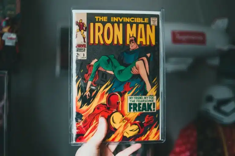 A person holding a vintage comic book titled The Invincible Iron Man, reminiscent of a tabletop RPG adventure. The cover features Iron Man carrying a woman over flames, with the text My friend, my foe, the fearsome freak! in a speech bubble, evoking that classic fantasy excitement.